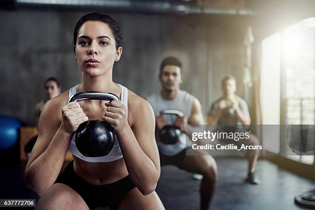 burning calories and strengthening her core with a kettlebell - weightlifting imagens e fotografias de stock