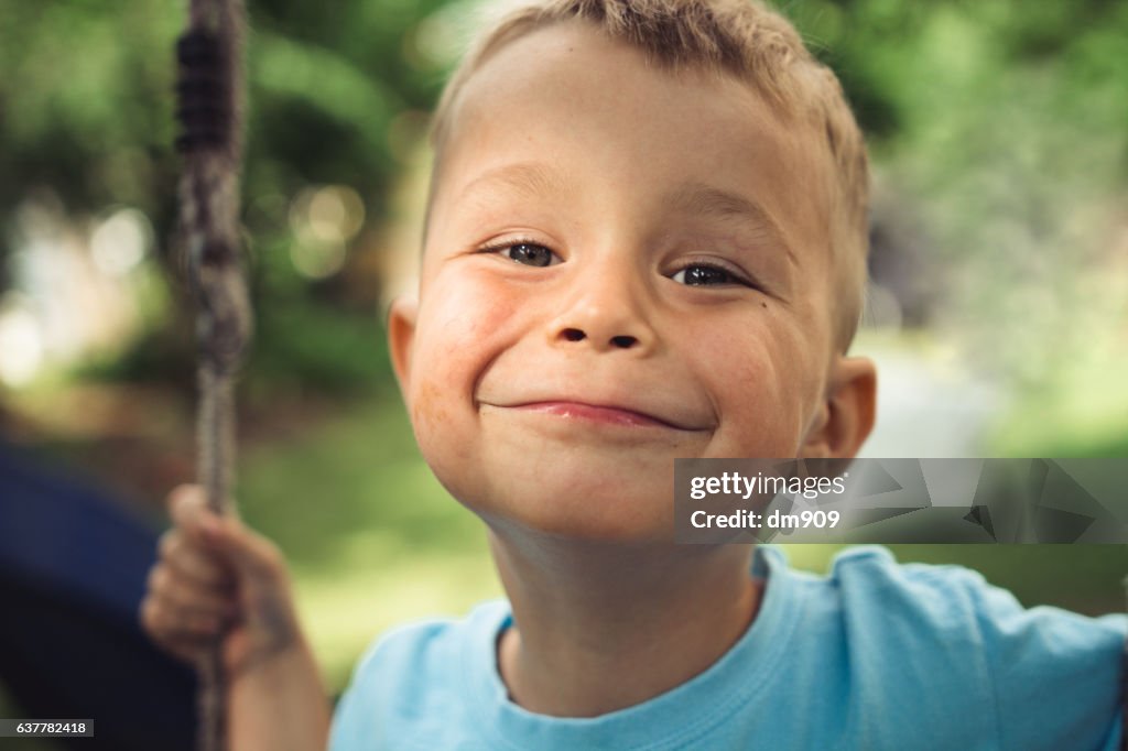 A smiling boy on a swing