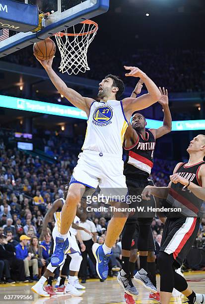 Zaza Pachulia of the Golden State Warriors drives to the basket for a layup over Maurice Harkless of the Portland Trail Blazers during an NBA...