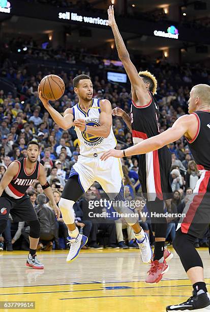 Stephen Curry of the Golden State Warriors looks to pass the ball over Allen Crabbe of the Portland Trail Blazers during an NBA basketball game at...