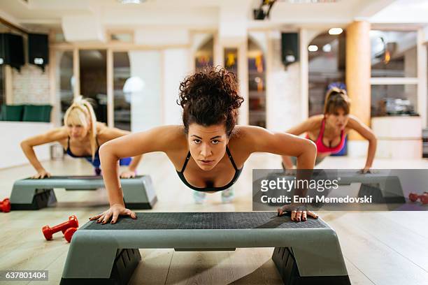 women doing push-ups on step aerobics equipment at gym. - 踏板操 個照片及圖片檔