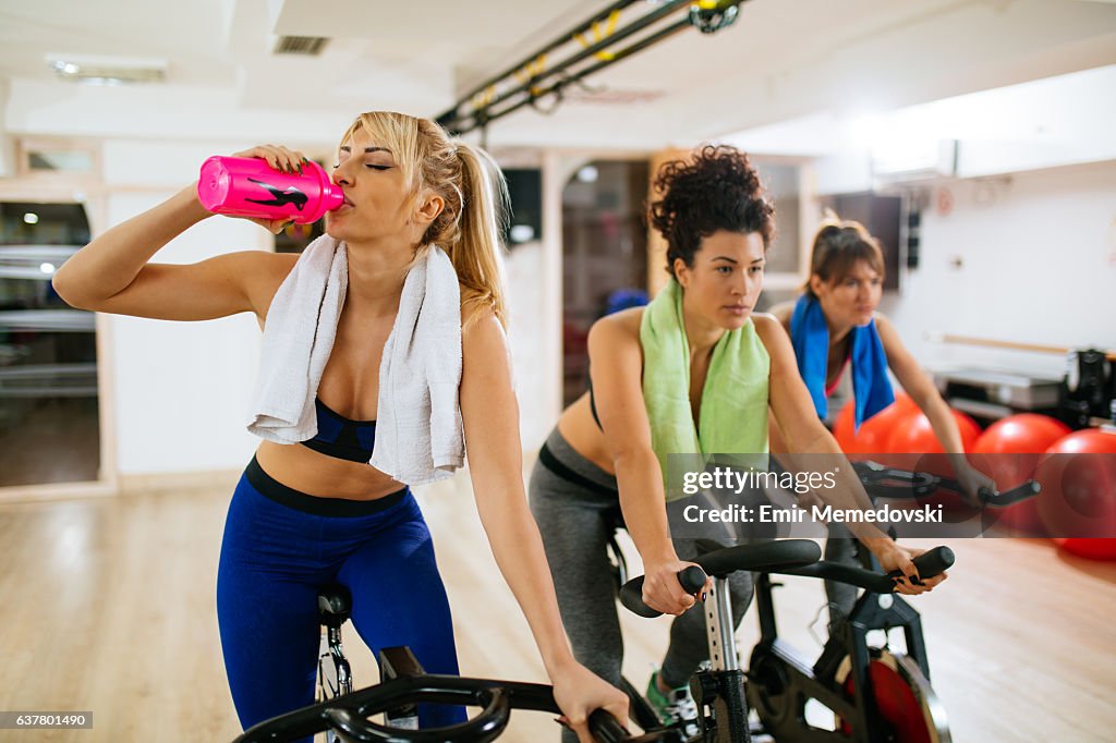 Young sporty woman drinking water during exercising training.