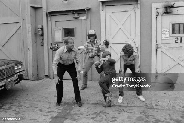 Dick Van Patten, Adam Rich, Willie Aames and Grant Goodeve, actors of television series Eight is Enough, playing football.