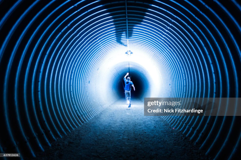 A person running inside a highway underpass at night in Winfield, Lake Country, British Columbia, Canada