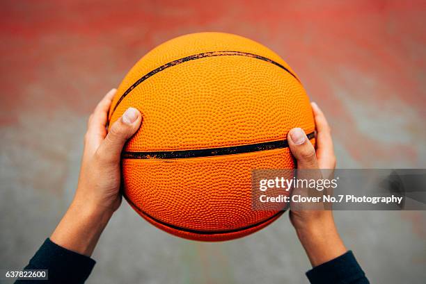 holding a basketball hand, pov. - exercise ball stock-fotos und bilder