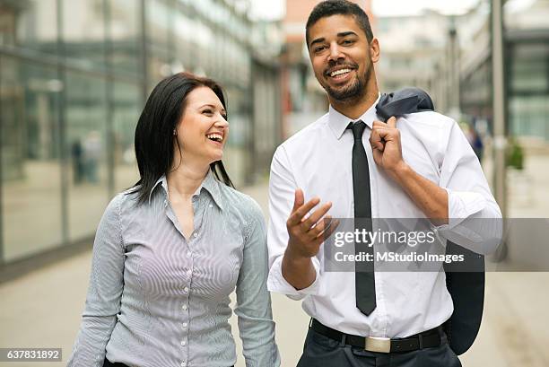 two smiling co-workers having a talk. - co op city stock pictures, royalty-free photos & images