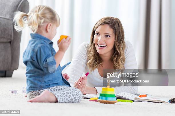 pretty mother and her preschool age daughter play together - nanny stock pictures, royalty-free photos & images
