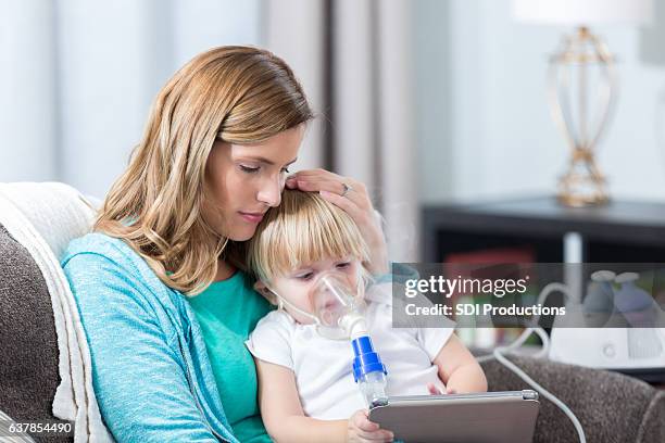 young girl with cystic fibrosis receives breathing treatment - oxygen mask stock pictures, royalty-free photos & images