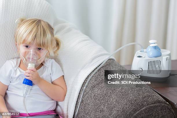 kaukasisches vorschulalter mädchen mit mukoviszidose erhält atembehandlung - oxygen mask stock-fotos und bilder