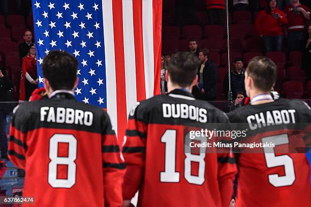 Members of Team Canada watch as the flag of the United States of America is raised after losing the gold medal round to Team United States during the...