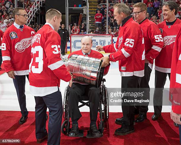 Former forward Darren McCarty and Kris Draper of the Detroit Red Wings 1997 Stanley Cup Team hands off the Stanley Cup to teammate Vladimir...