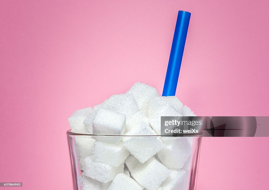 Glass full of sugar cubes - unhealthy diet concept.
