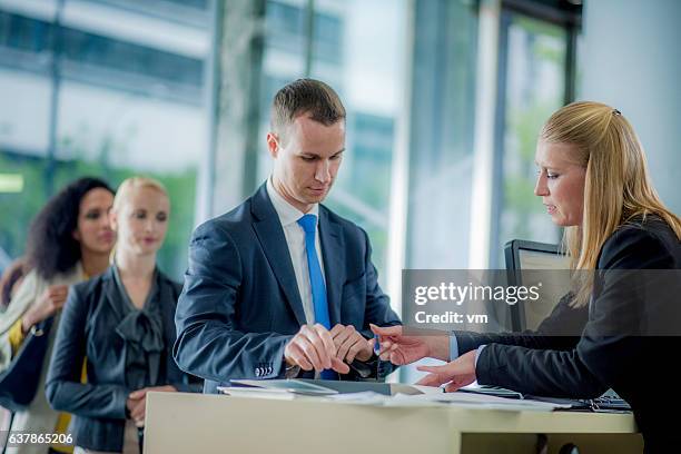 hombre que se prepara para firmar un contrato bancario - cajero fotografías e imágenes de stock