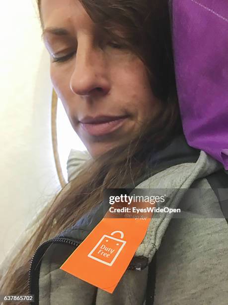 Female flight passenger with a sticker Wake me up for Duty Free on board of a Airbus A 380 on the way to Myanmar via Dubai at Munich Airport on...