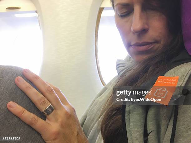 Female flight passenger with a sticker Wake me up for Duty Free on board of a Airbus A 380 on the way to Myanmar via Dubai at Munich Airport on...