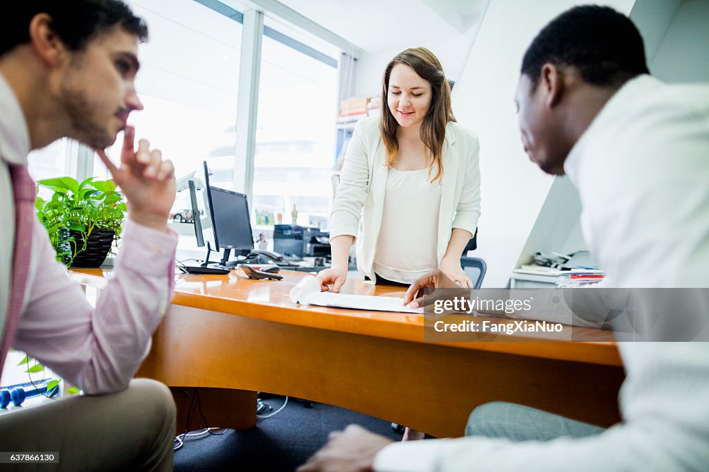 Geschäftsfrau im Gespräch mit Kollegen im Büro