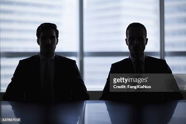 silhouette pair of businessmen in meeting room - ominous 個照片及圖片檔