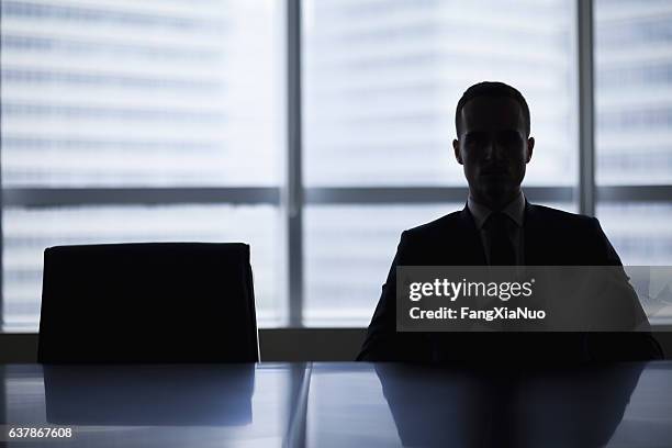 silhouette des geschäftsmannes im büro-meetingraum - dark background light stock-fotos und bilder