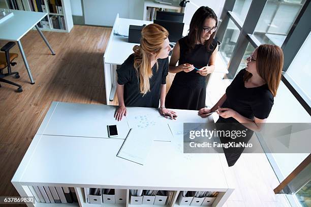 mulheres conversando juntas no escritório de planejamento de design - job centre - fotografias e filmes do acervo