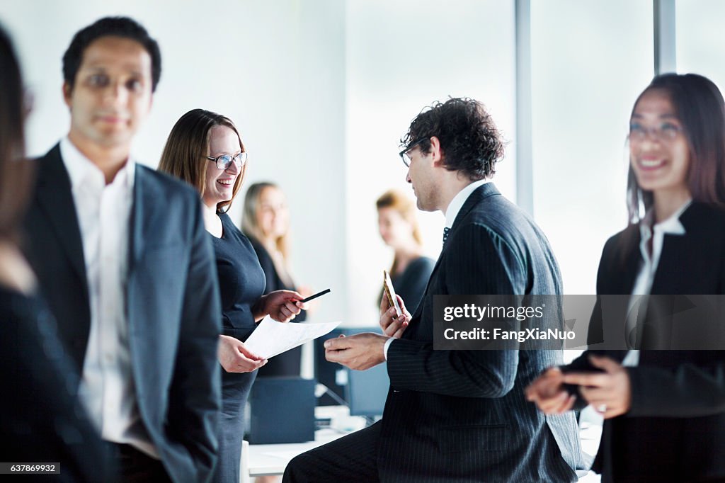 Group of business colleagues talking together in office