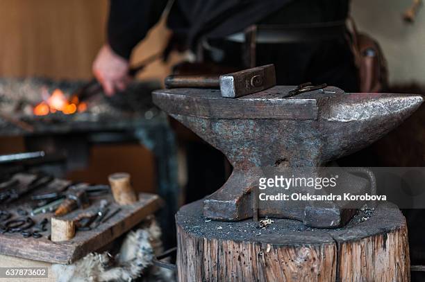 blacksmith at the workshop. - amboss stock-fotos und bilder
