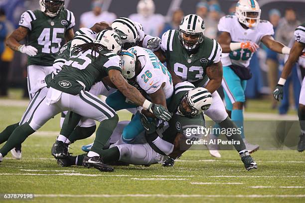 Safety Calvin Pryor and Defensive End Sheldon Richardson the New York Jets lead a gang tackle against the Miami Dolphins at MetLife Stadium on...