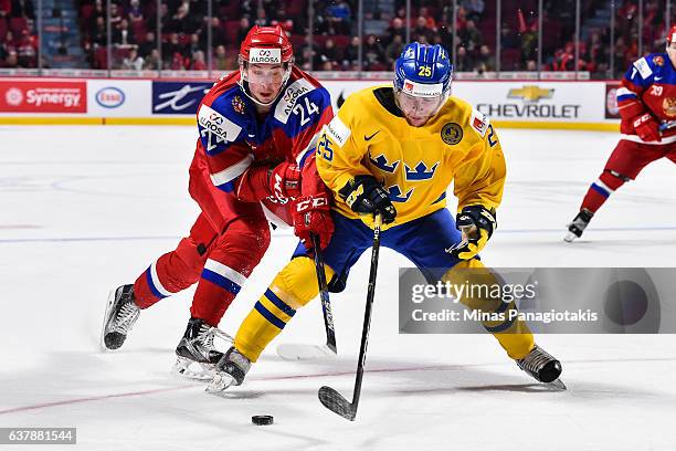 Sebastian Ohlsson of Team Sweden and Mikhail Vorobyev of Team Russia skate after the puck during the 2017 IIHF World Junior Championship bronze medal...