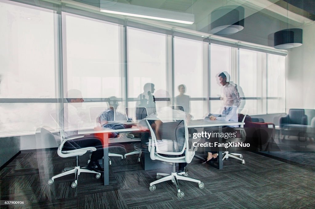 Reflections of business colleagues having meeting in office