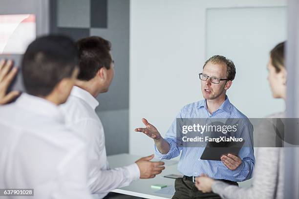 man hosting business meeting in office - impact stock pictures, royalty-free photos & images