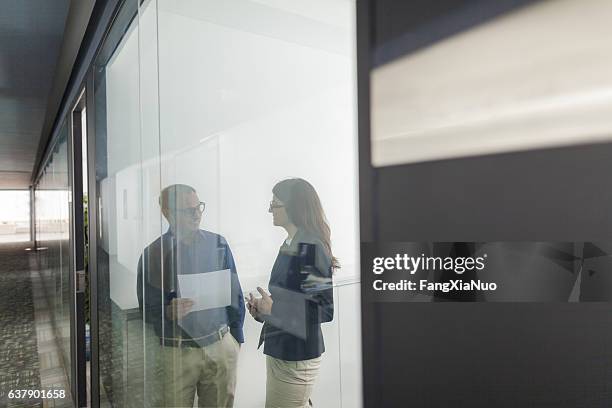 pair of colleagues talking together in office - unusual angle stock pictures, royalty-free photos & images
