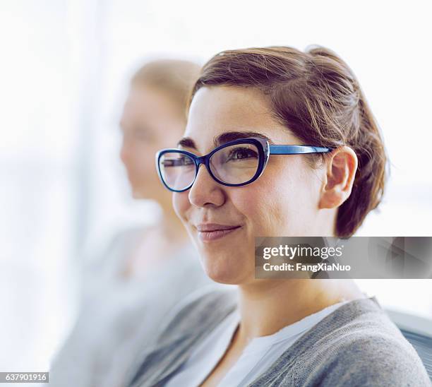 woman smiling in office meeting - ronde stockfoto's en -beelden