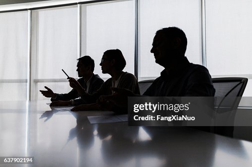 Silhouette von Geschäftsleuten, die am Besprechungstisch verhandeln Silhouette von Geschäftsleuten, die am Besprechungstisch verhandeln
