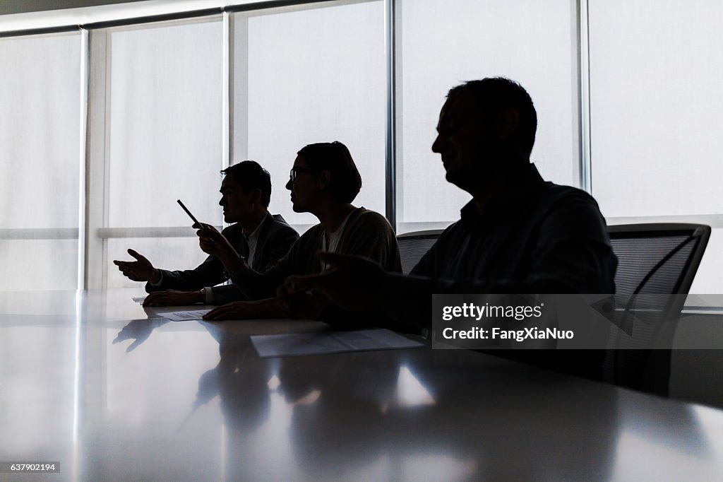 Silhouette of business people negotiating at meeting table