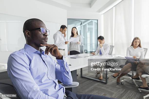 hombre de negocios pensando durante la reunión en la oficina - tímido fotografías e imágenes de stock