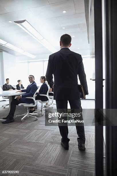 uomo d'affari che entra in una sala riunioni - governing board foto e immagini stock