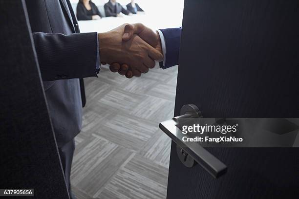 handshake in office meeting room - corruption imagens e fotografias de stock