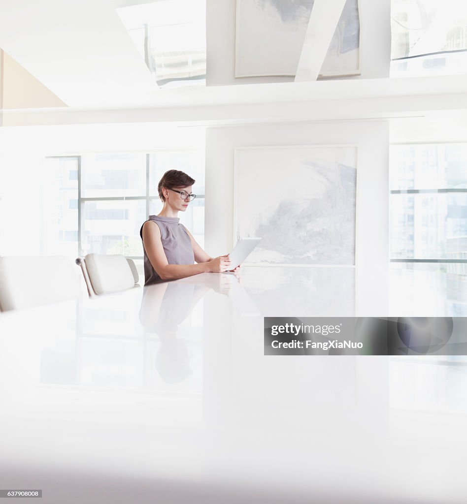 Woman sitting using tablet computer in room