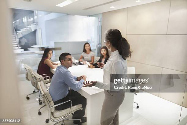 woman leading business presentation in conference room - senior orientation announcement stock pictures, royalty-free photos & images