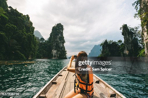 Female tourist exploring lush Jungle lake surrounded by limestone cliffs, Khao Sok National Park, Thailand Female tourist exploring lush Jungle lake surrounded by limestone cliffs, Khao Sok National Park, Thailand