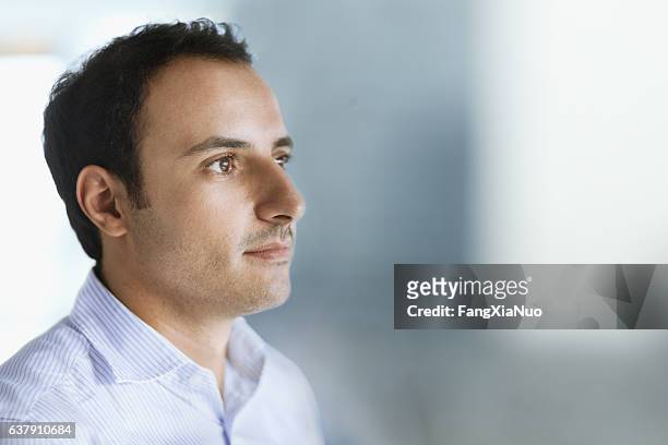 joven mirando hacia adelante en el espacio de oficinas - business man profile fotografías e imágenes de stock