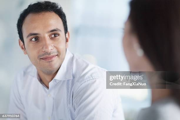 young man looking at colleague in office - escritório tecnologia olhar em frente imagens e fotografias de stock