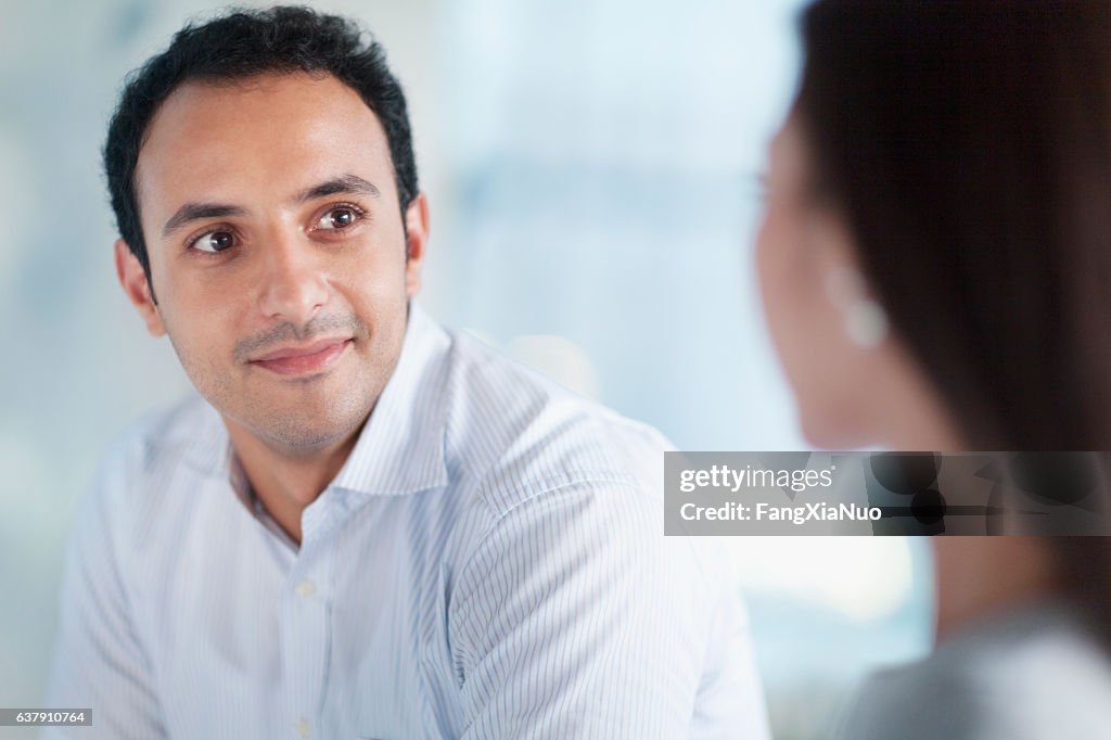 Young man looking at colleague in office