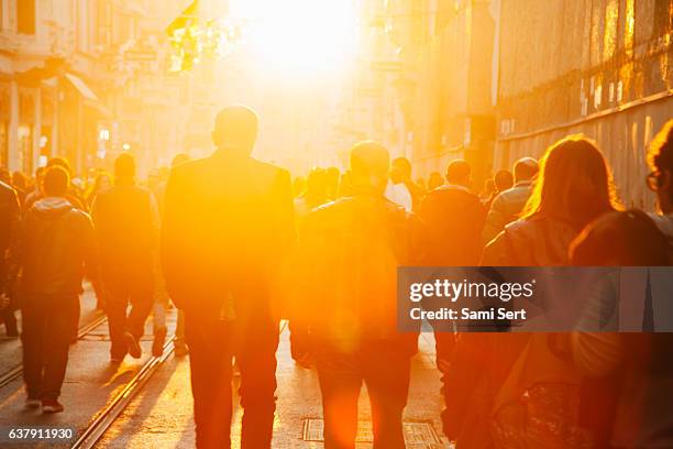 crowd on street in bright lens flare - city footpath stock pictures, royalty-free photos & images