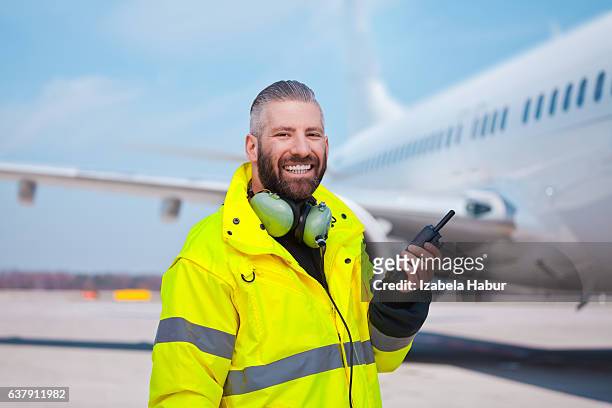 ground crew using walkie-talkie outdoor in front of aircraft - aviation worker stockfoto's en -beelden