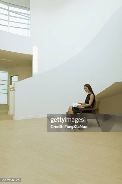 現代の建物ロビーで読書本を読む女性 - bendy ストックフォトと画像