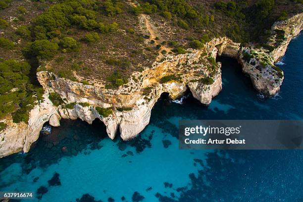 aerial picture taking with drone flying over the beautiful menorca island in the cala macarella beach with nice turquoise water and stunning landscape. - cala macarelleta - fotografias e filmes do acervo