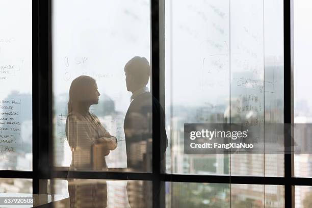 silhouette shadows of business people looking at city in office - internal conflict stock pictures, royalty-free photos & images