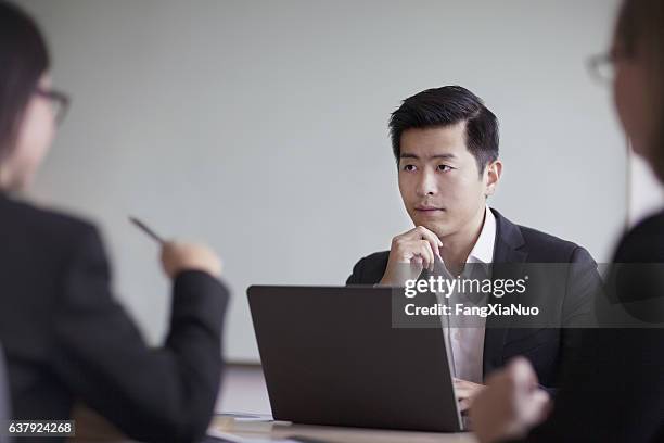 hombre de negocios mirando a través de la mesa en la reunión de la oficina - masters degree fotografías e imágenes de stock