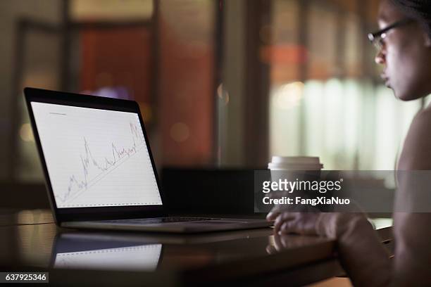 woman viewing laptop screen with graph diagram - accessibility website stock pictures, royalty-free photos & images