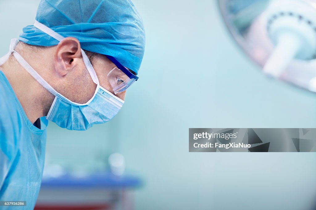 Médico mirando hacia abajo al paciente en el quirófano del hospital